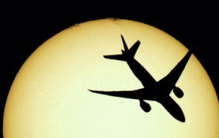 Aircraft flying across disc of the sun